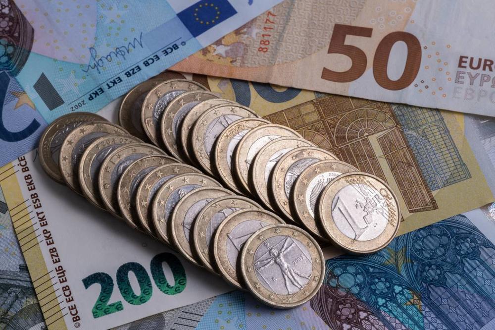 Une pile de pièces de monnaie et de billets en euros.