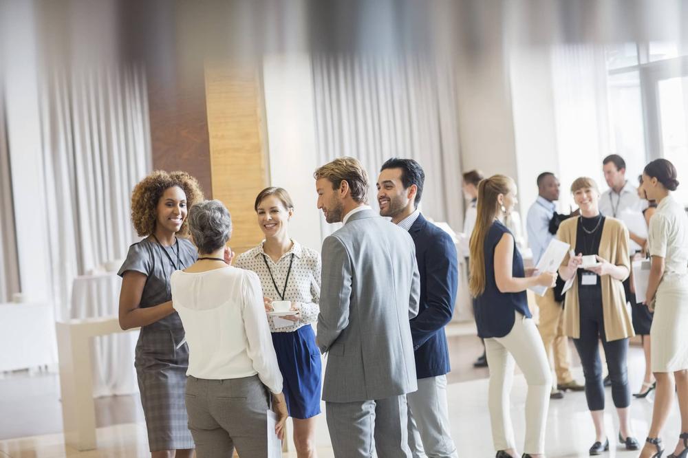 Un groupe de personnes discutent dans un hall dhôtel.